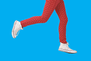 Legs of a person wearing red leggings and converse