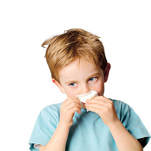 A little boy wiping his nose with a tissue