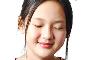 A girl with her eyes closed and smiling