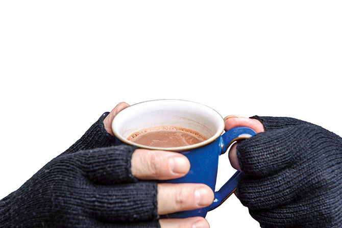 a pair of hands holding a mug of hot chocolate