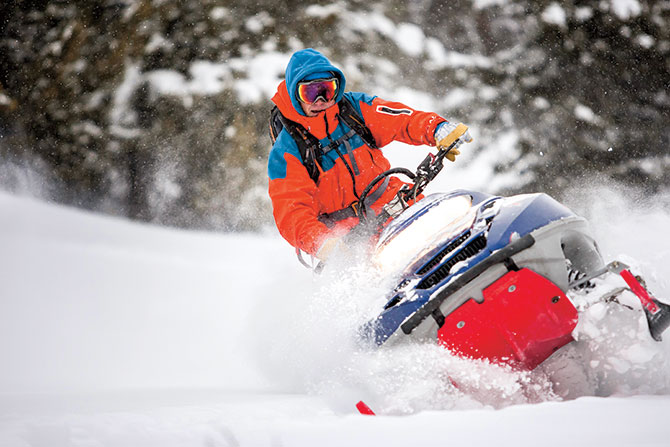 A person driving a snow mobile