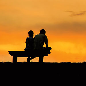 Children sitting and the sunset