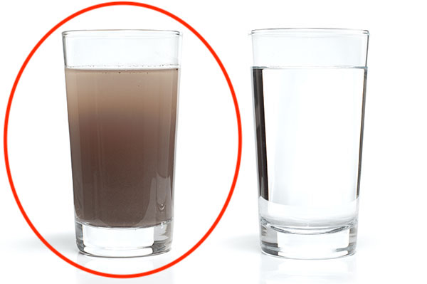 A glass of clear water next to a glass of dirty brown water