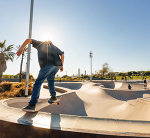 Photo of a skateboarder at the top of a ramp at skatepark