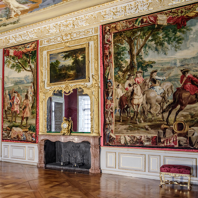 A wall covered in framed cloth artworks