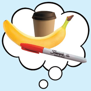 a cup of coffee with a banana and a red Sharpie in front of it